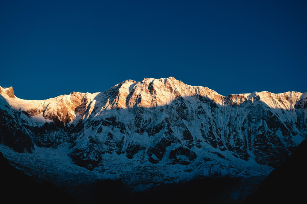 a snow covered mountain with a blue sky in the background