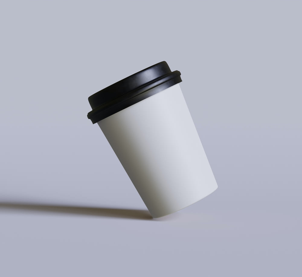 a white coffee cup with a black lid