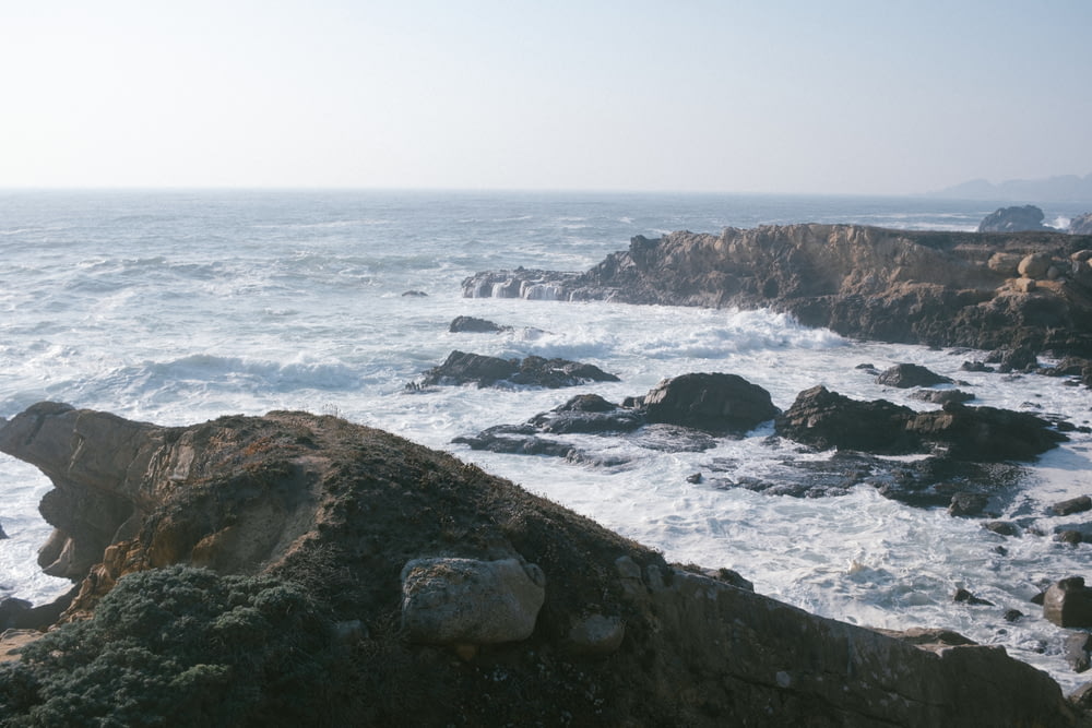 uma costa rochosa com um grande corpo de água