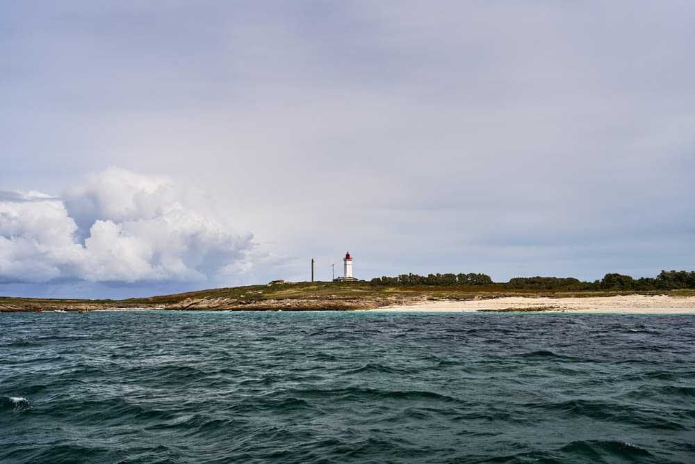 a lighthouse on a small island in the middle of the ocean