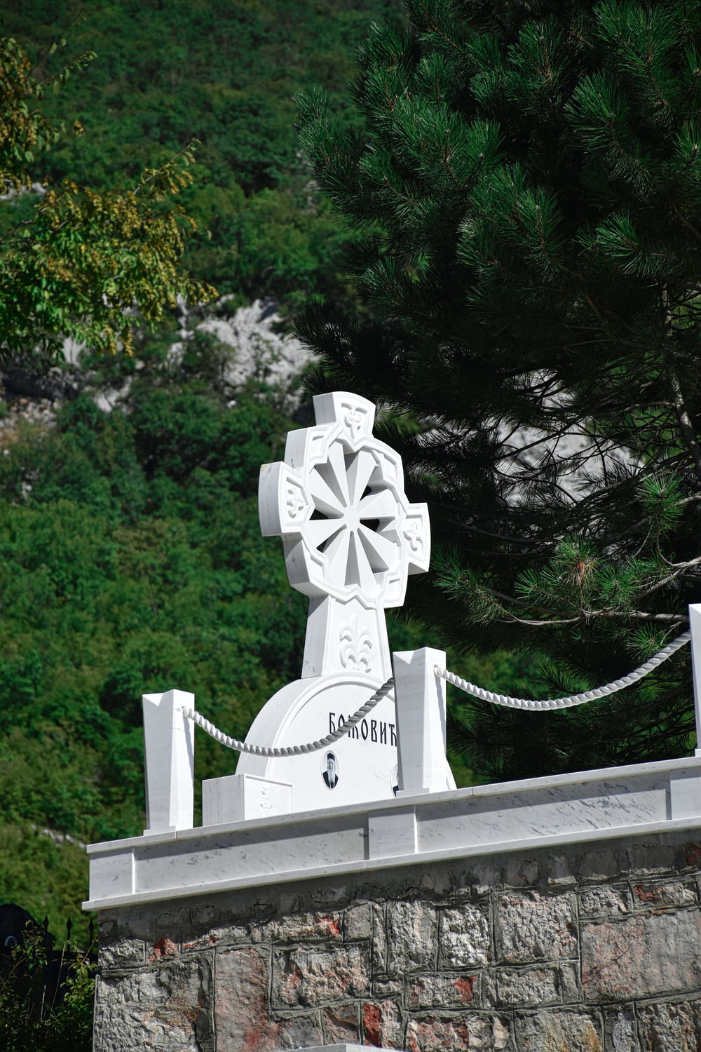 a white cross on top of a stone wall