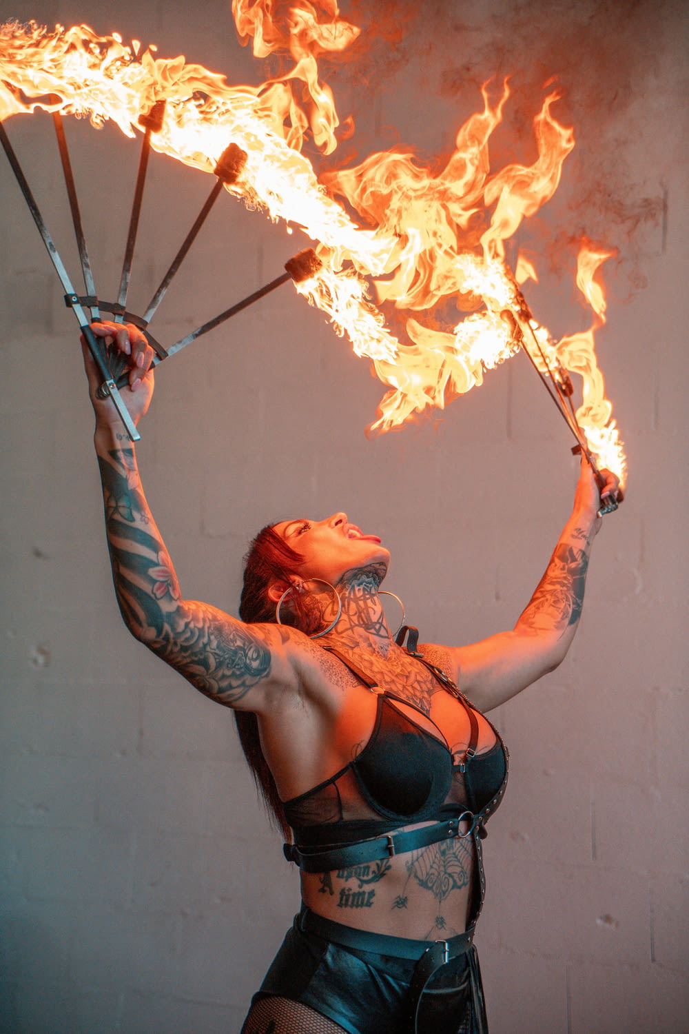 a woman holding two fire torches in her hands