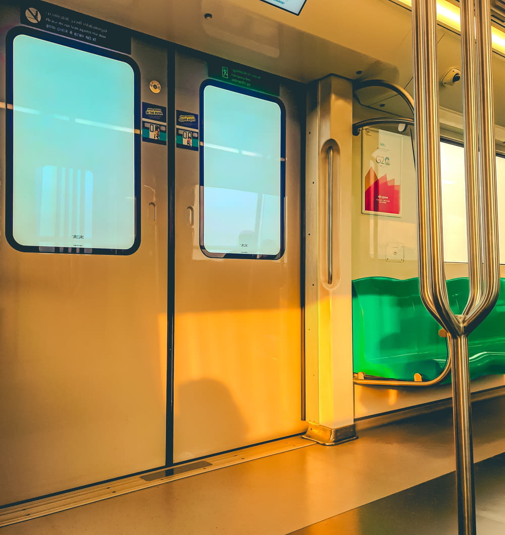 ein U-Bahn-Waggon mit grünen Sitzen und gelber Tür