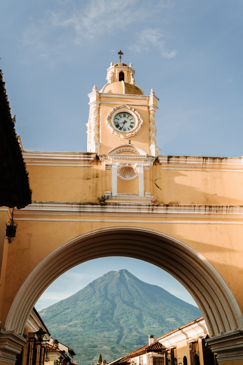 a clock tower with a mountain in the background
