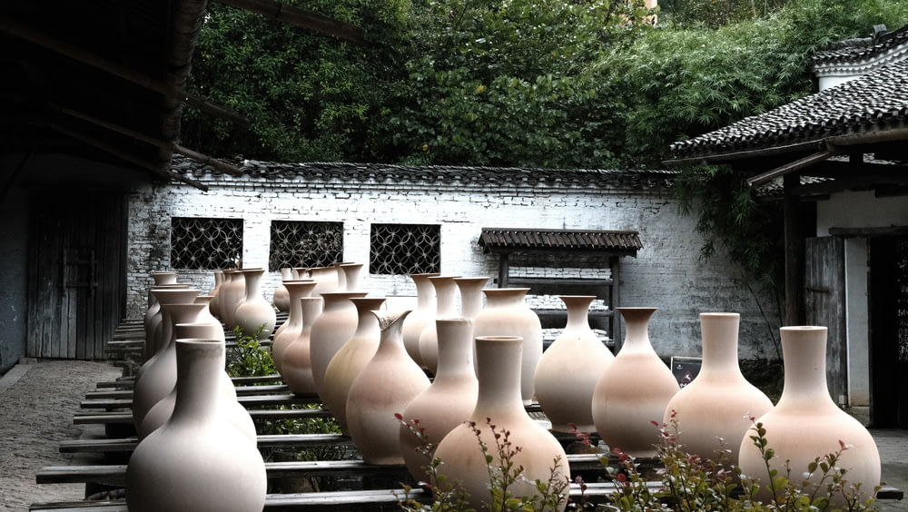 a bunch of vases are lined up in a row