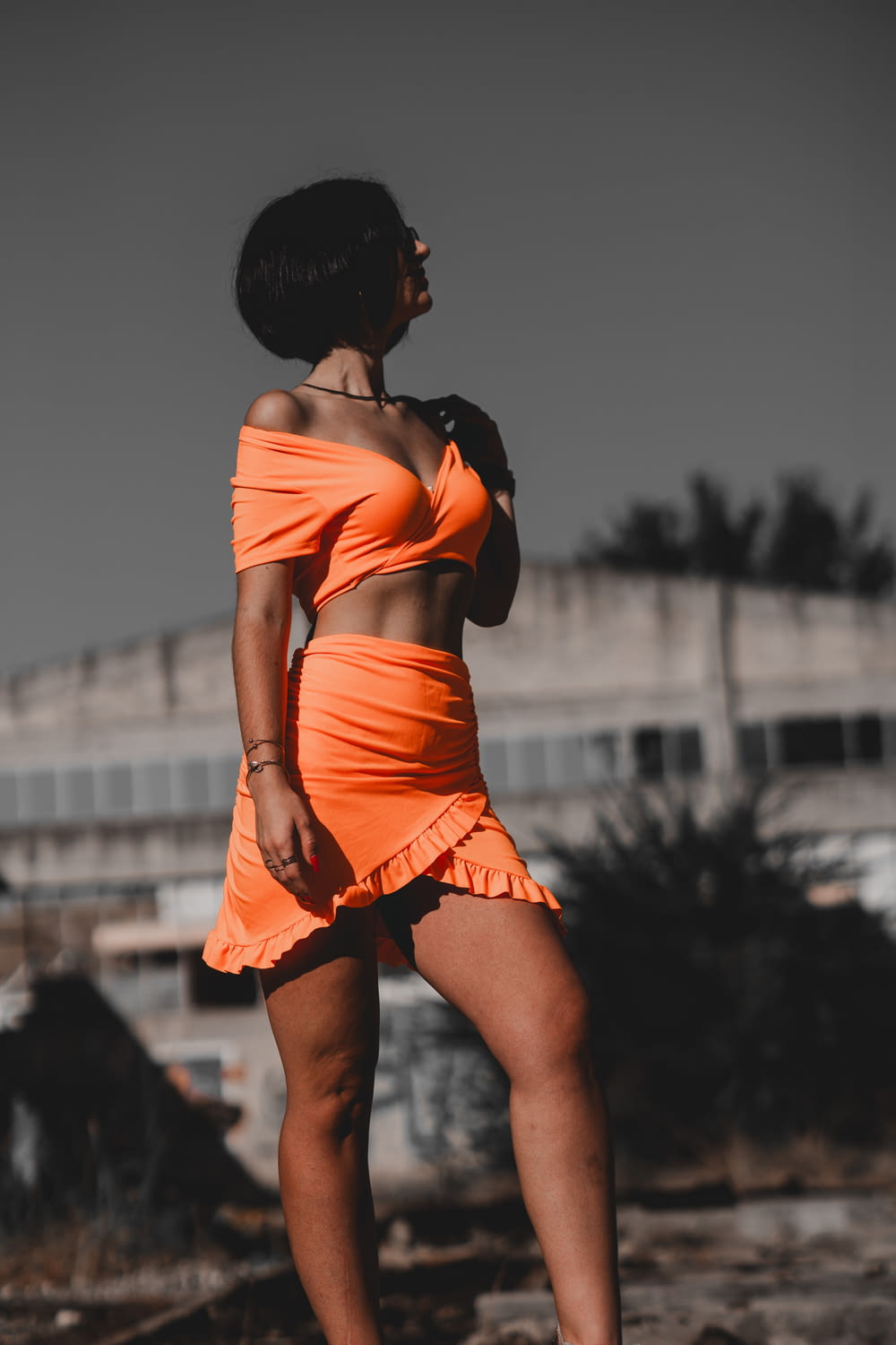 a woman in an orange dress standing on a beach