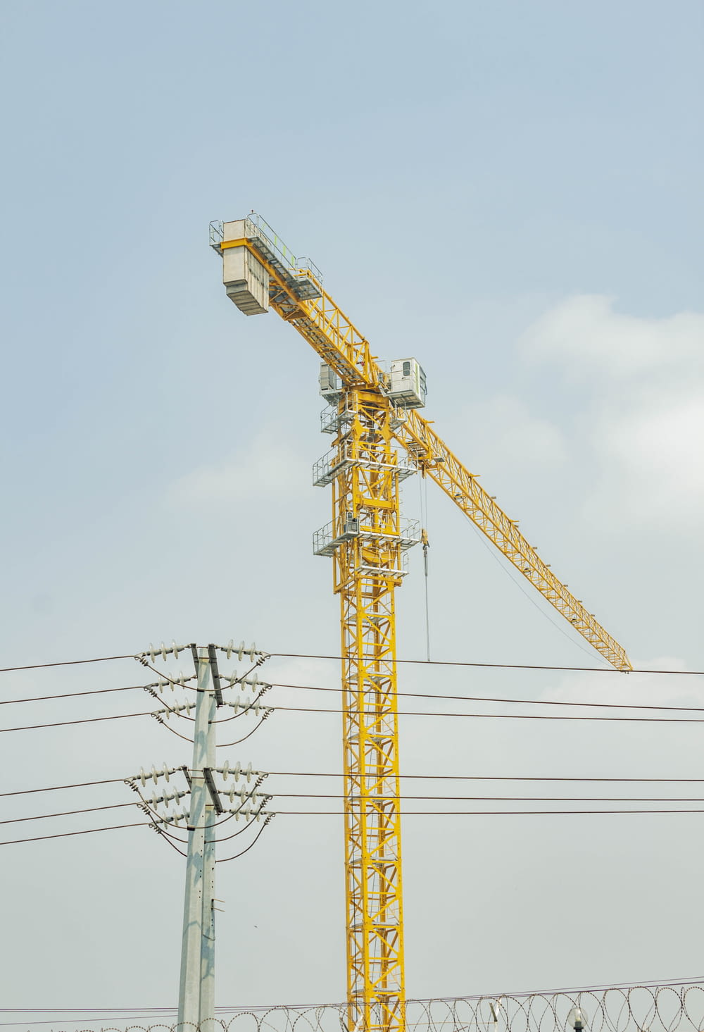 a yellow crane sitting on top of a metal pole