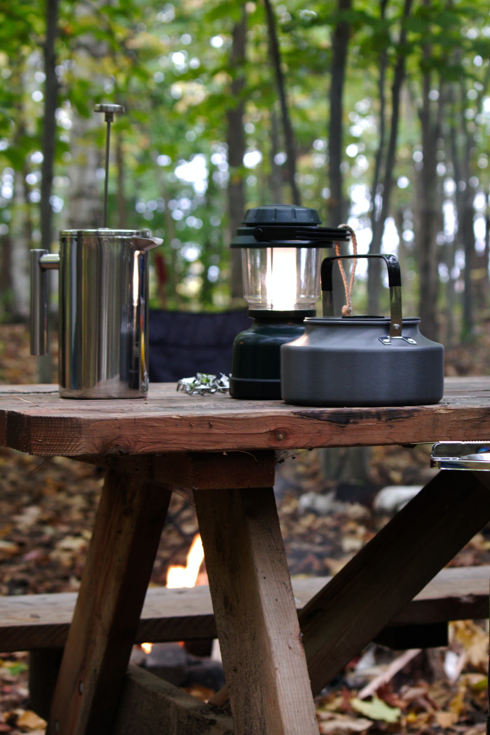 a picnic table with a coffee pot and a kettle on it