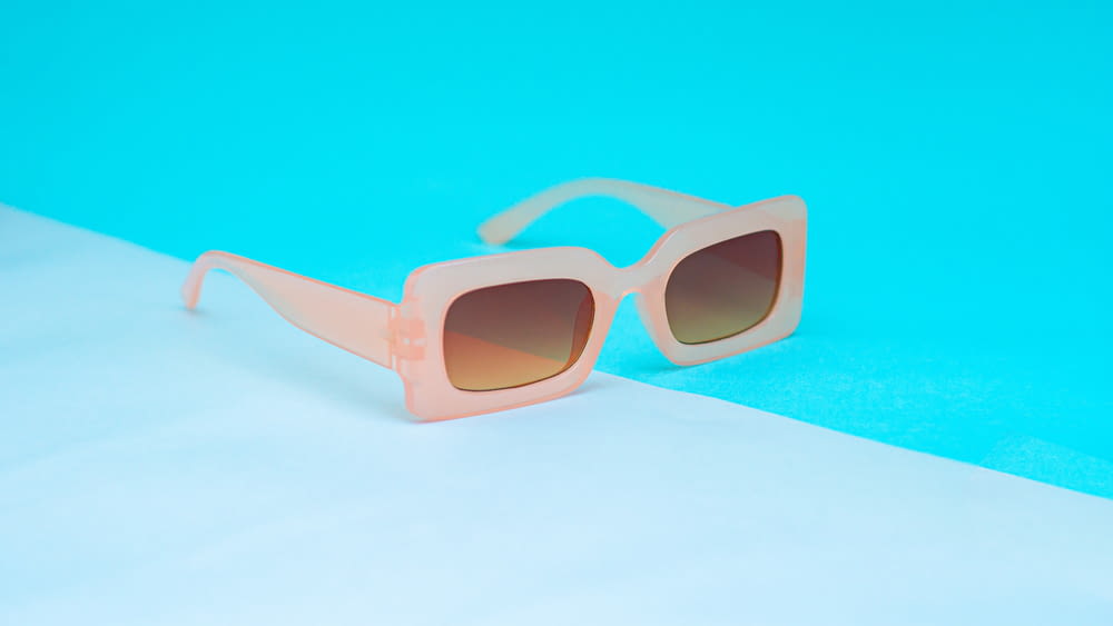 a pair of sunglasses sitting on top of a blue surface