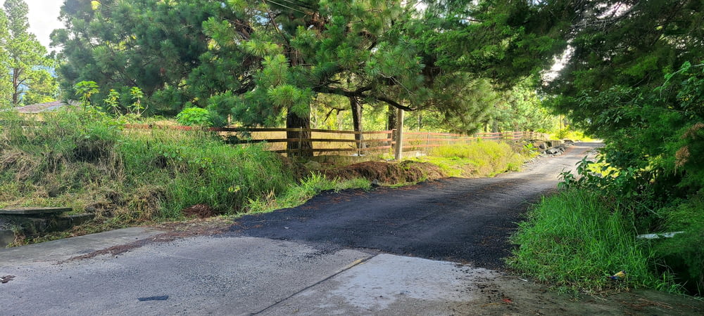 a dirt road with a gate on the side of it