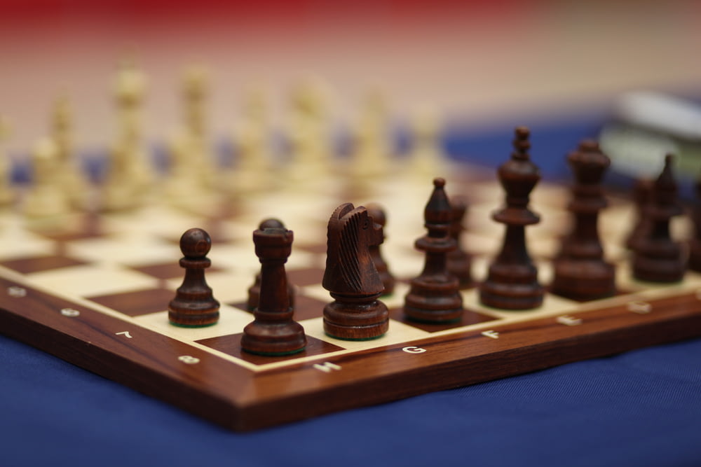a wooden chess board with pieces on it