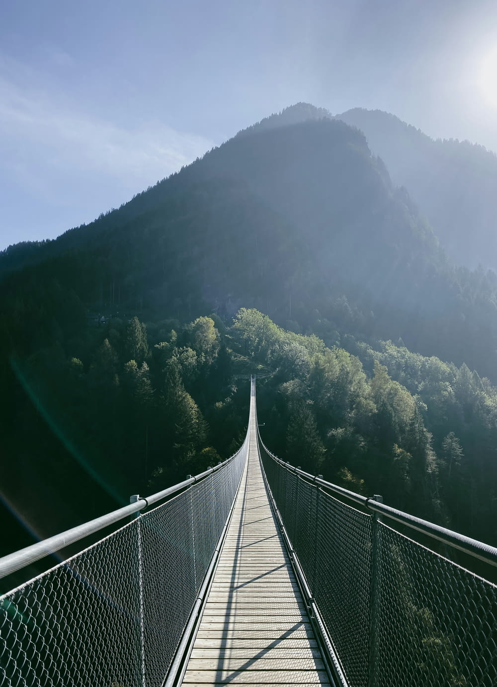 Un largo puente colgante con una montaña al fondo