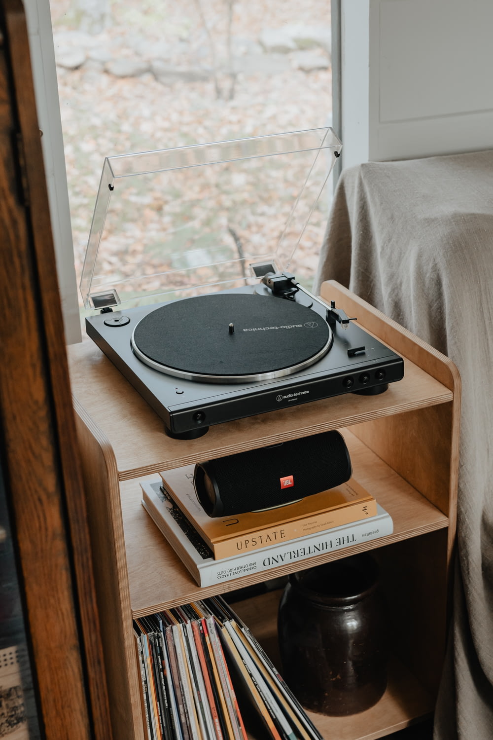 a record player sitting on top of a wooden shelf