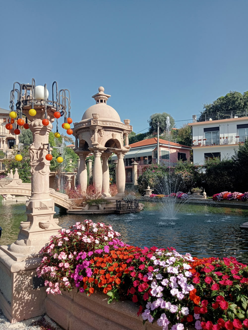a fountain surrounded by flowers in a park