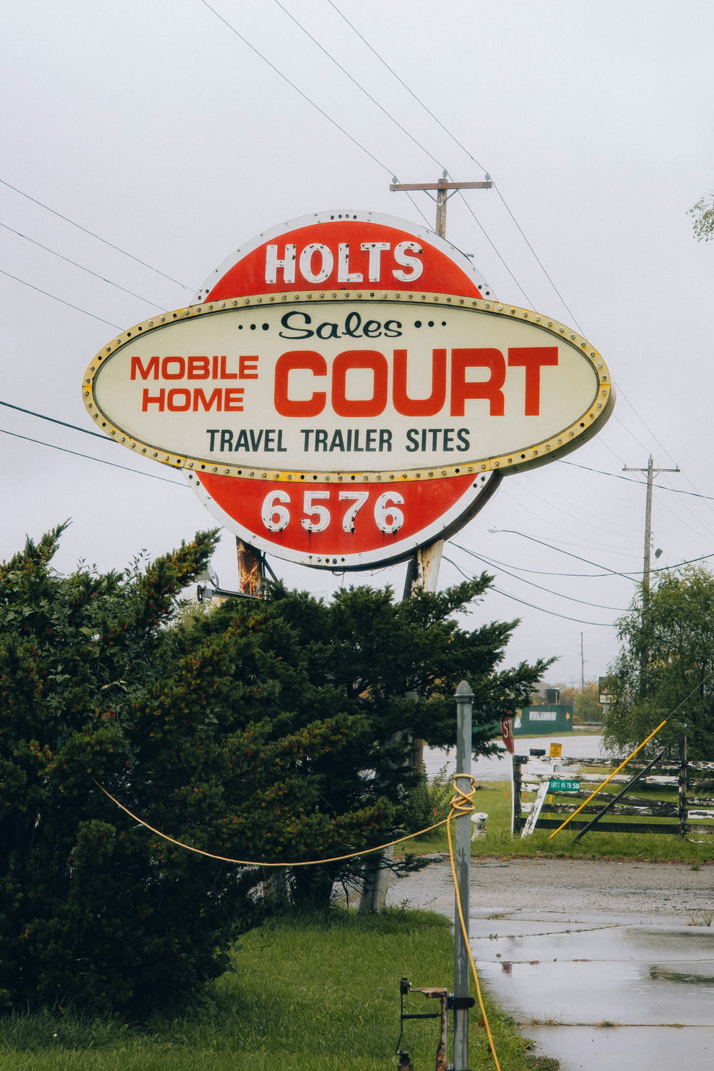 a neon sign for a mobile court sits on the side of the road
