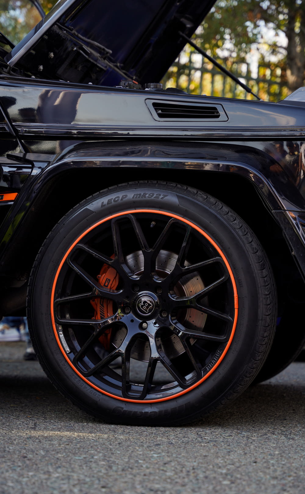 a close up of a black jeep with orange rims