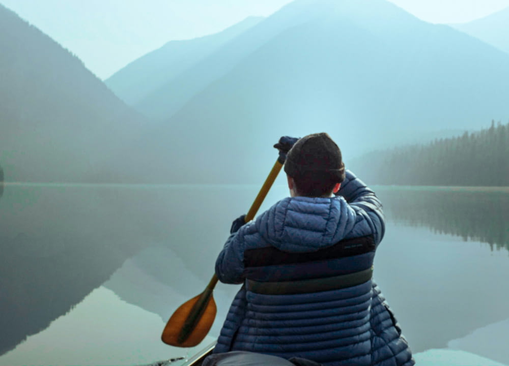 a man is paddling a canoe on a lake