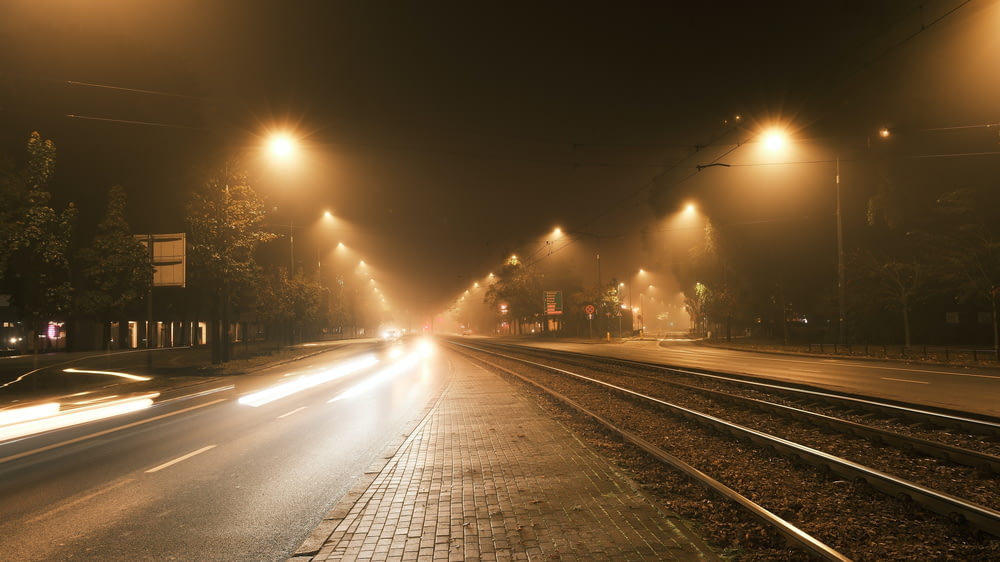 a foggy city street at night with street lights