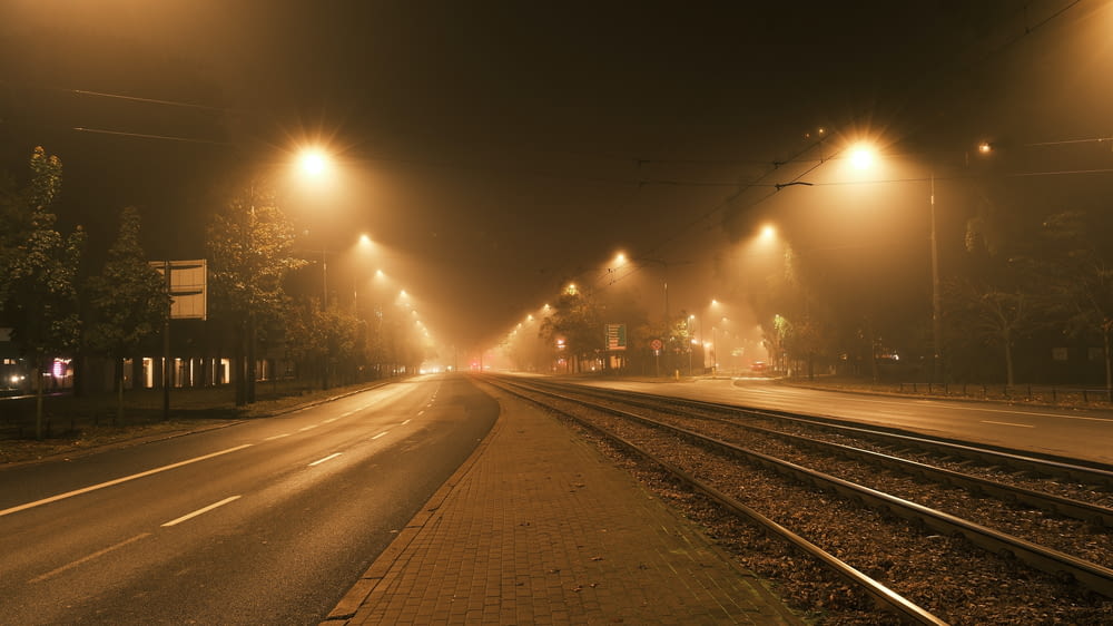 a foggy city street at night with street lights