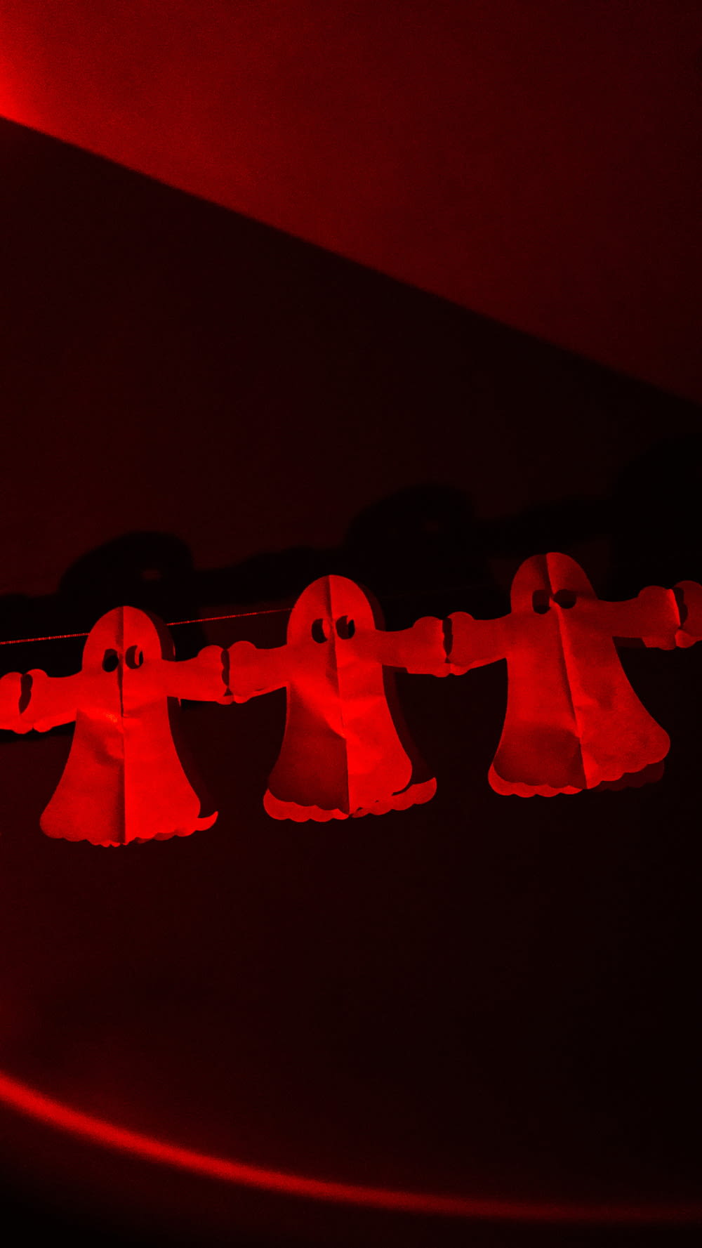 un gruppo di campane appese a una luce rossa