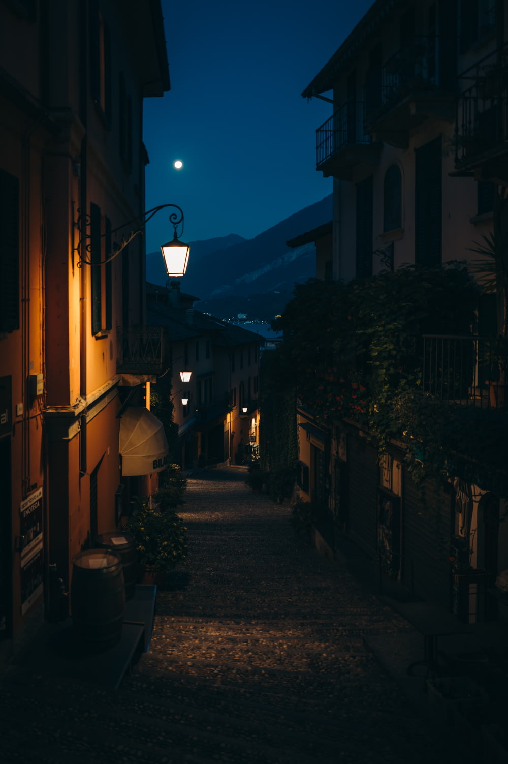 a dark alley way with a street lamp on the side