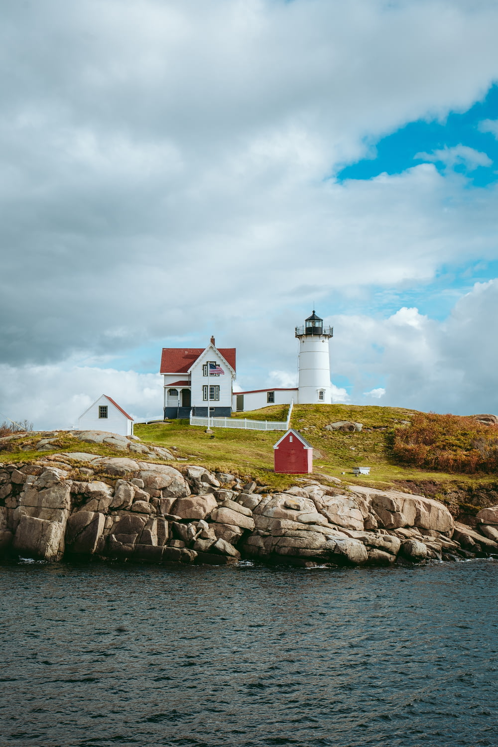 a red and white lighthouse on a rocky island