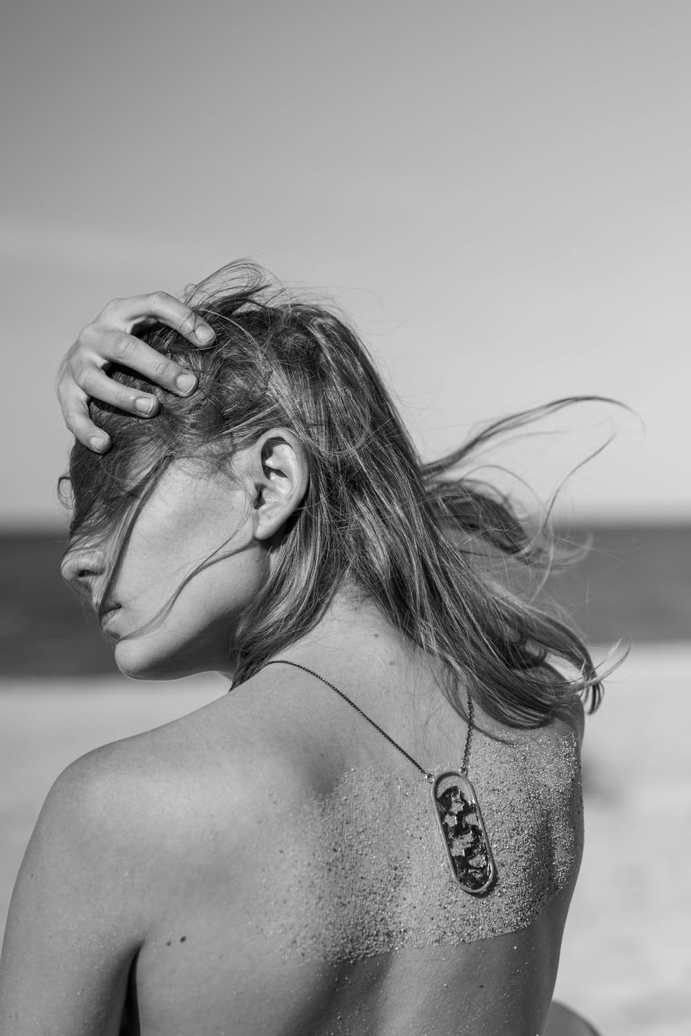 a woman with a tattoo on her back at the beach
