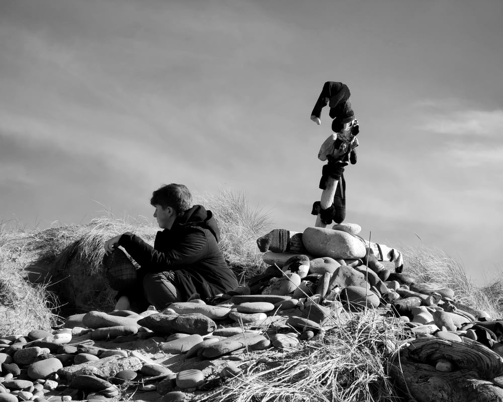 a couple of people sitting on top of a pile of rocks