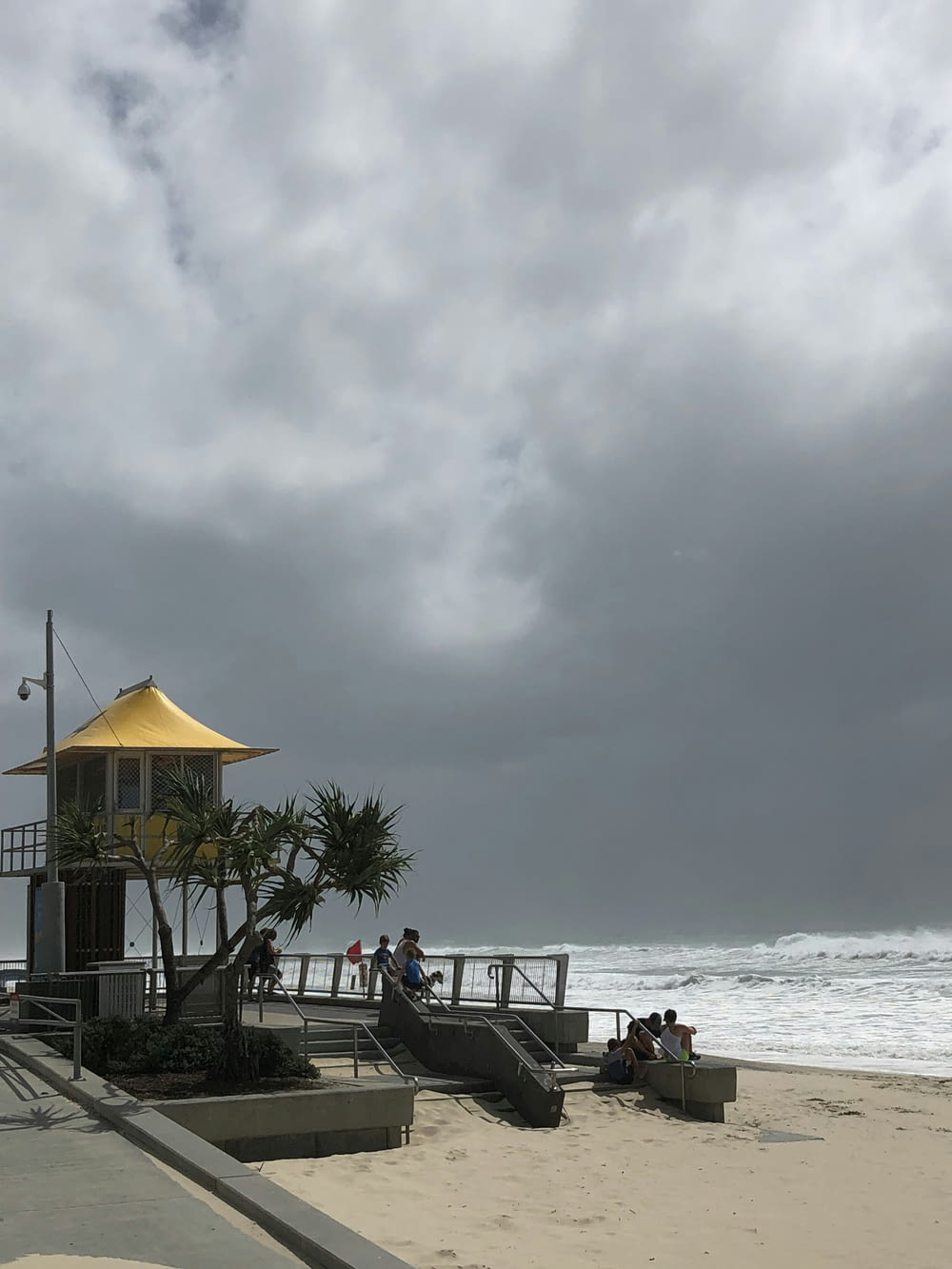 a lifeguard station on the beach with a cloudy sky