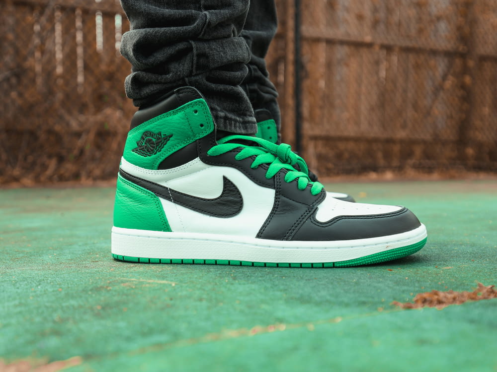 a pair of green and white sneakers on a court