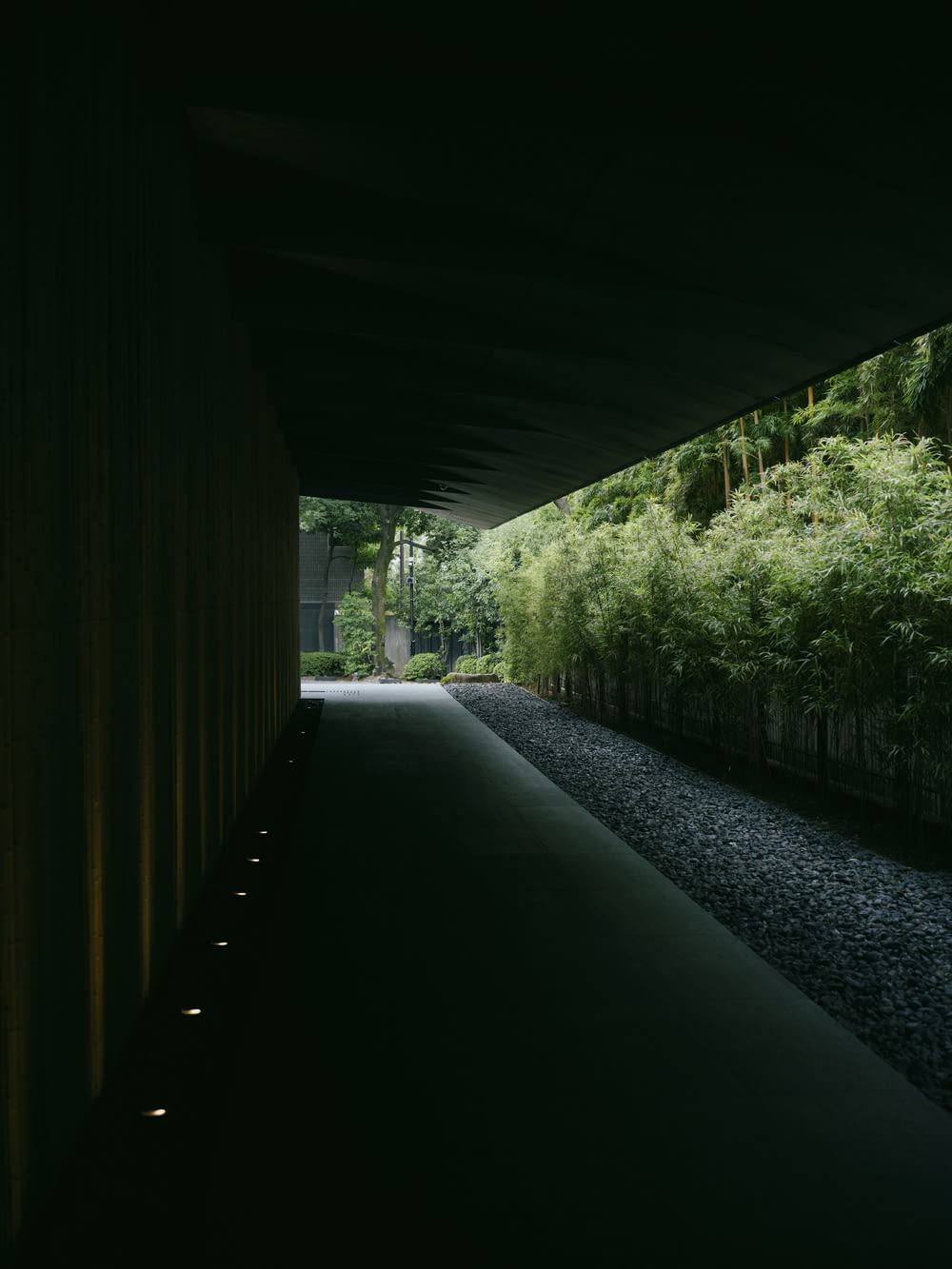 a dark tunnel with a walkway between two buildings