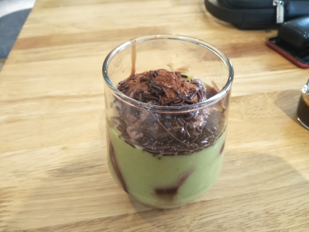 a glass filled with a dessert on top of a wooden table