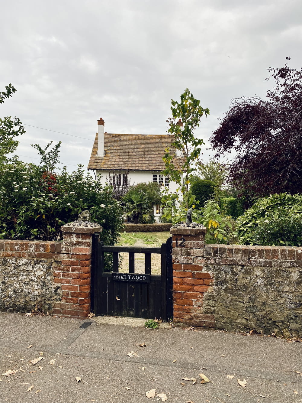 a brick wall with a gate in front of a house