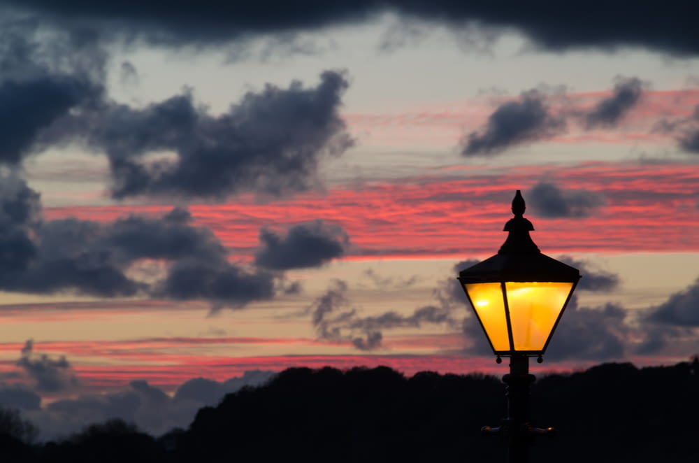 a street light with a sunset in the background