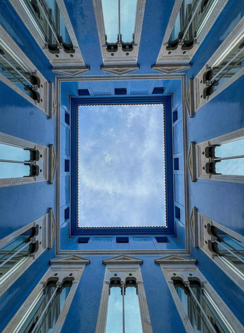 a blue and white building with a sky in the middle