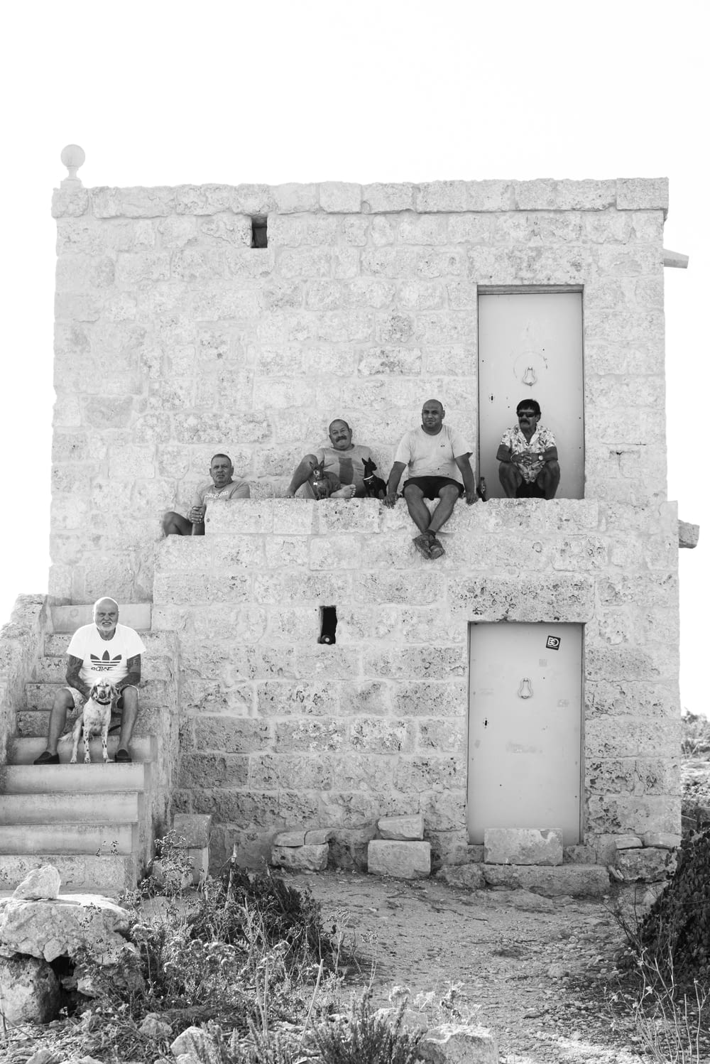 a group of men sitting on the outside of a building