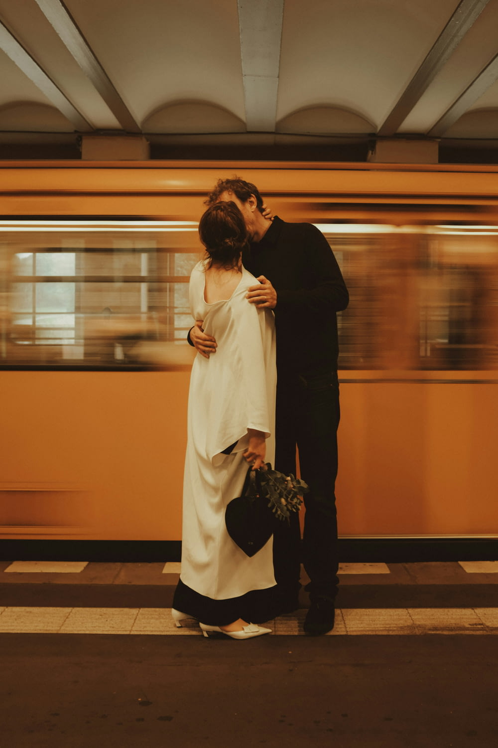 a man and a woman standing next to a train