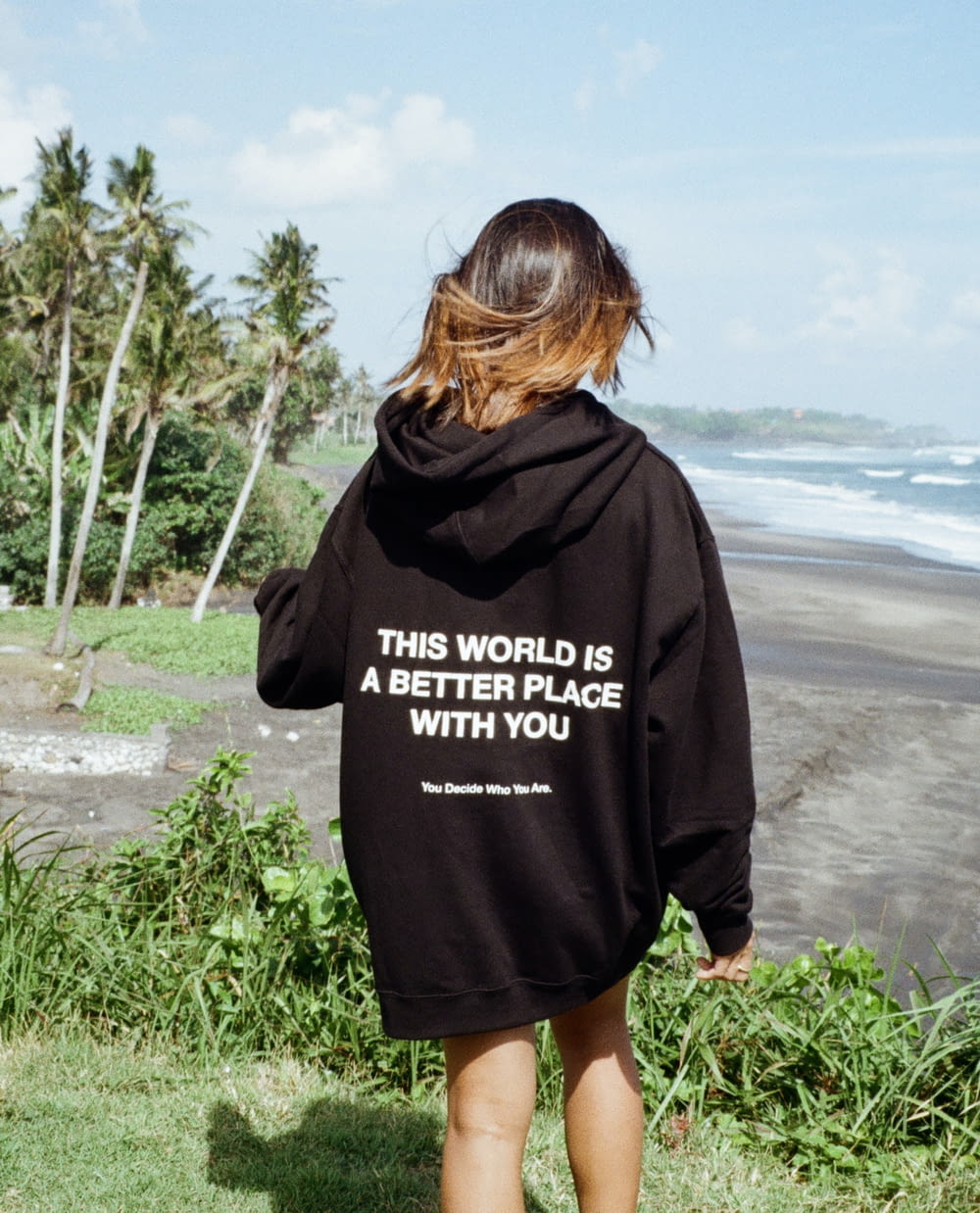 a woman in a black hoodie that says, this world is a better place