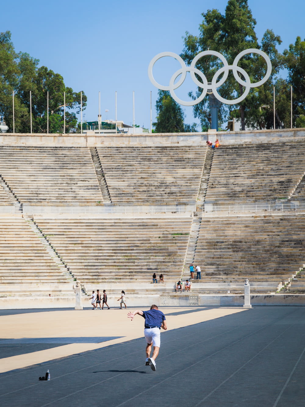 Um homem anda de skate em frente a um estádio