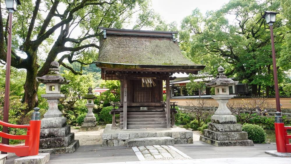 a small building with a thatched roof in a park