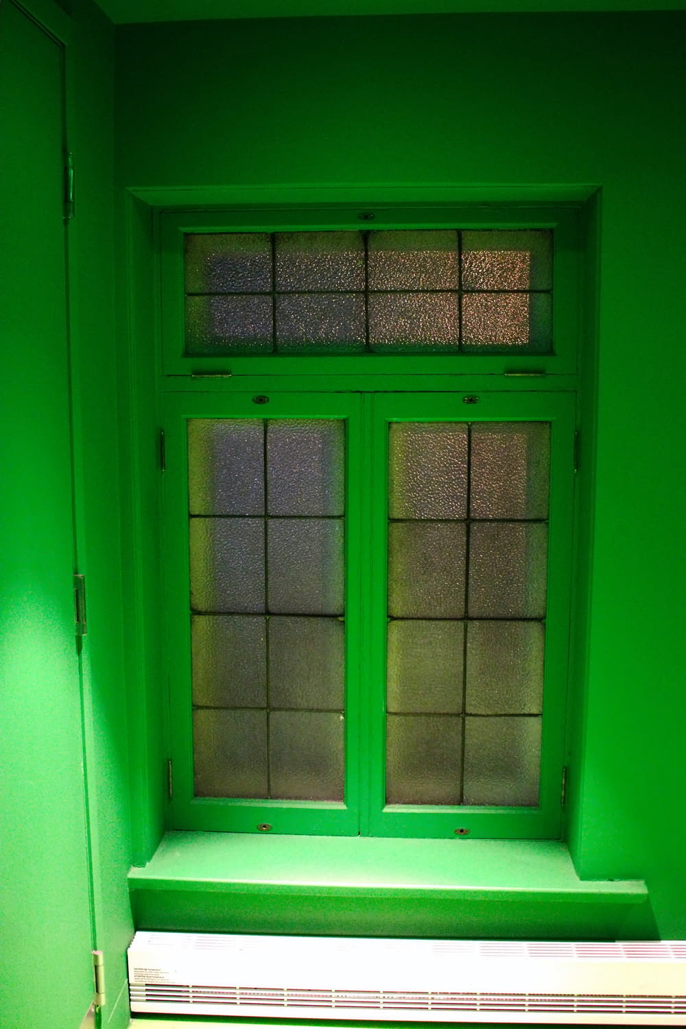 a green room with a window and a radiator
