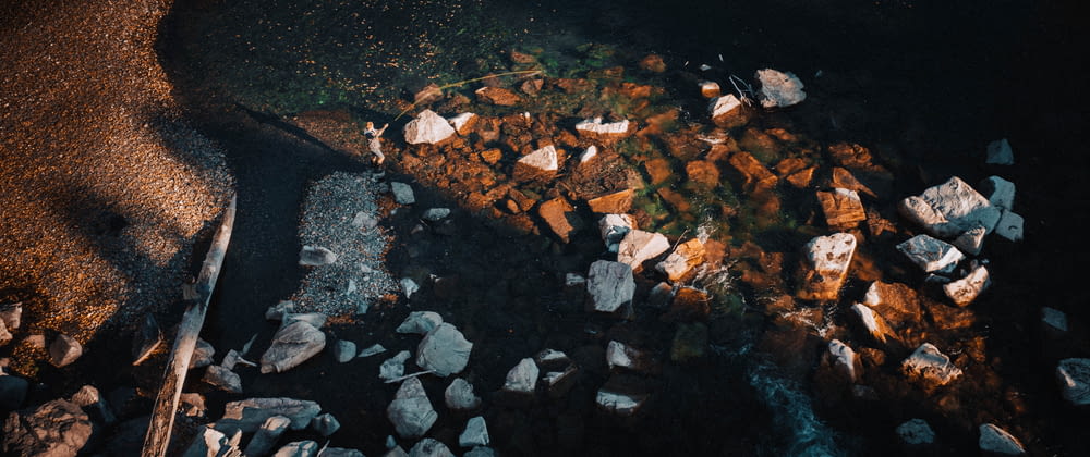 an aerial view of rocks and water at night