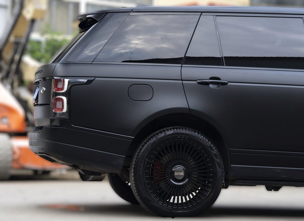 a black range rover parked in front of a building