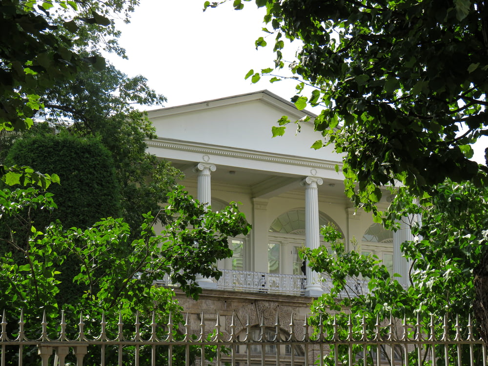 a white house with columns and a white fence