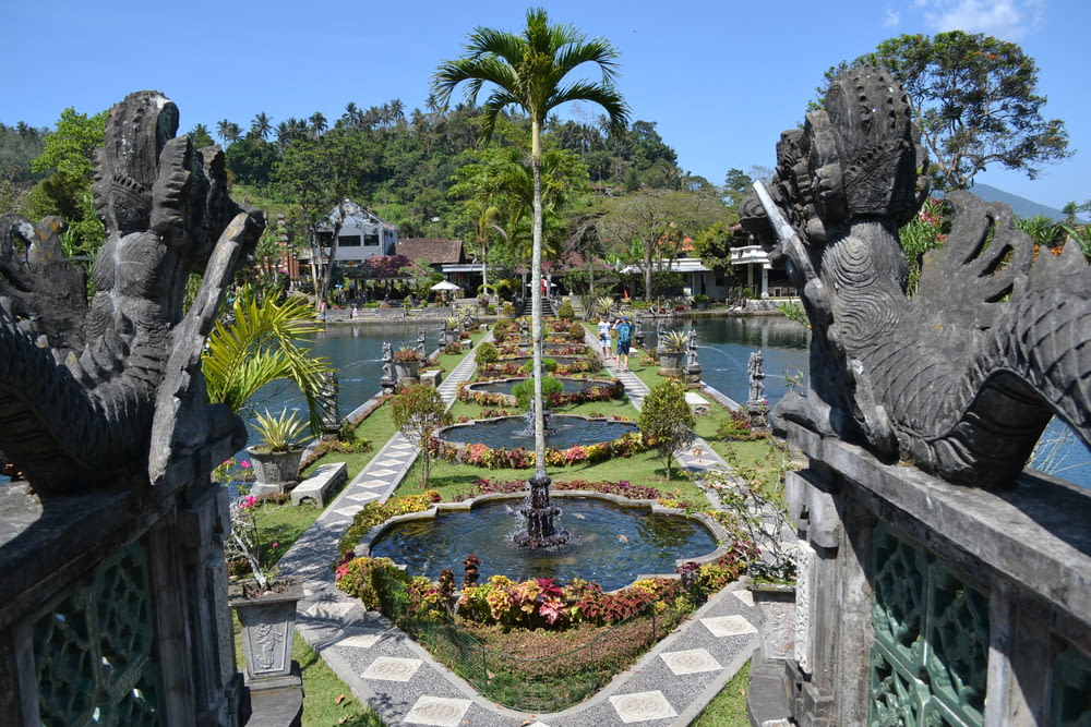 a garden with a fountain surrounded by statues