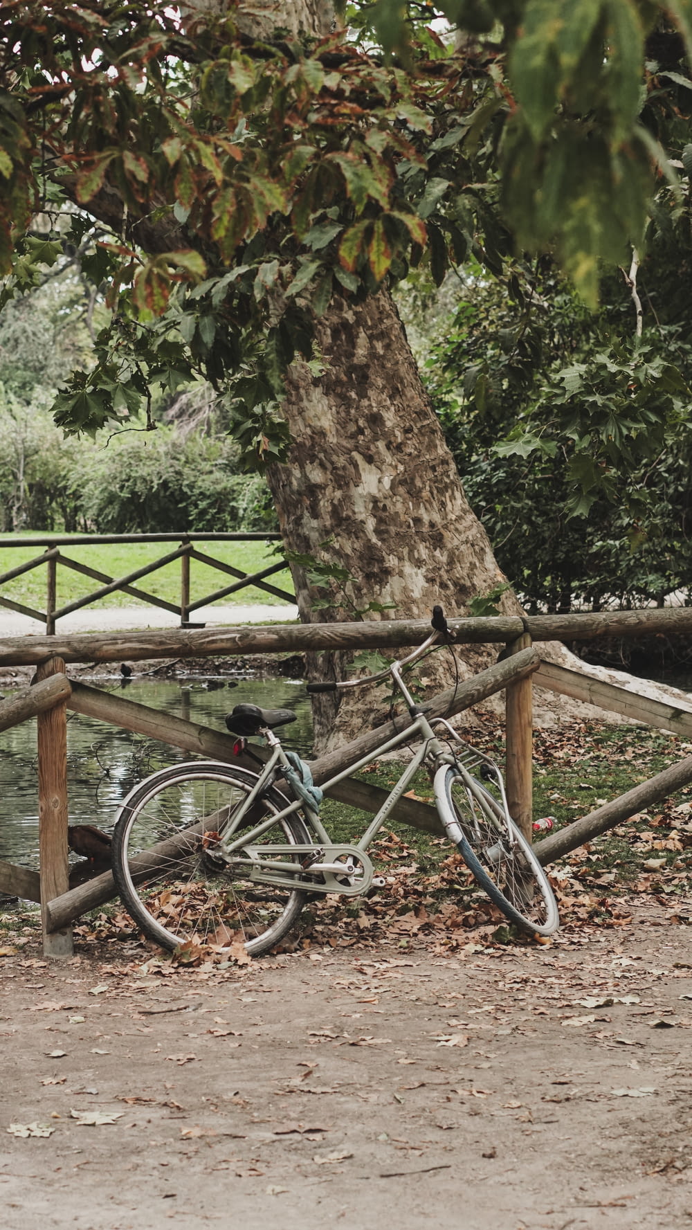 a bike leaning against a wooden fence in a park