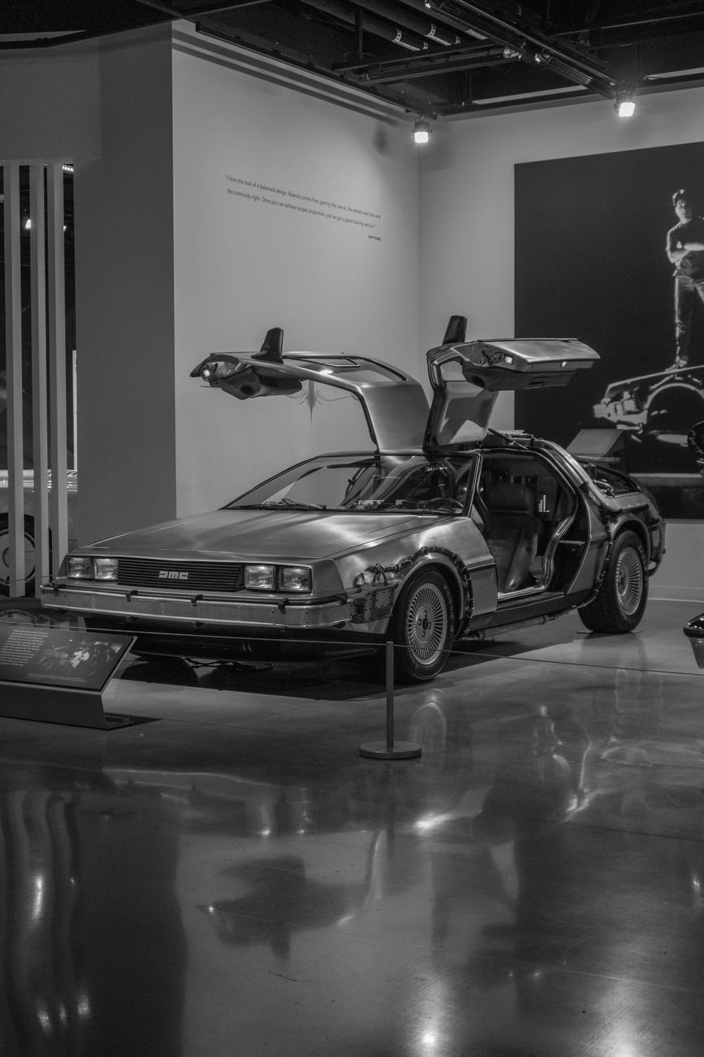 a black and white photo of a car in a museum