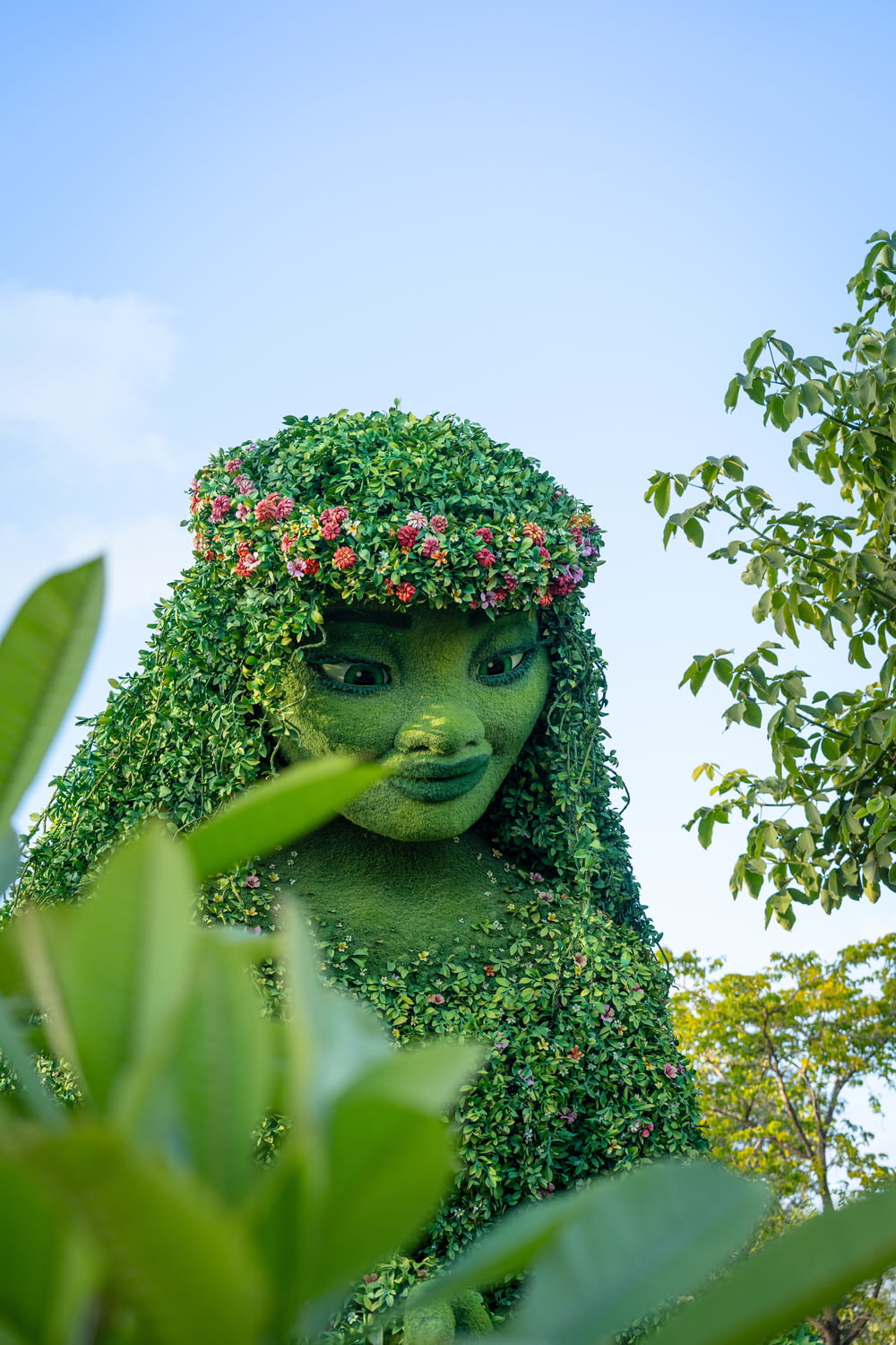 a woman with green hair and flowers on her head