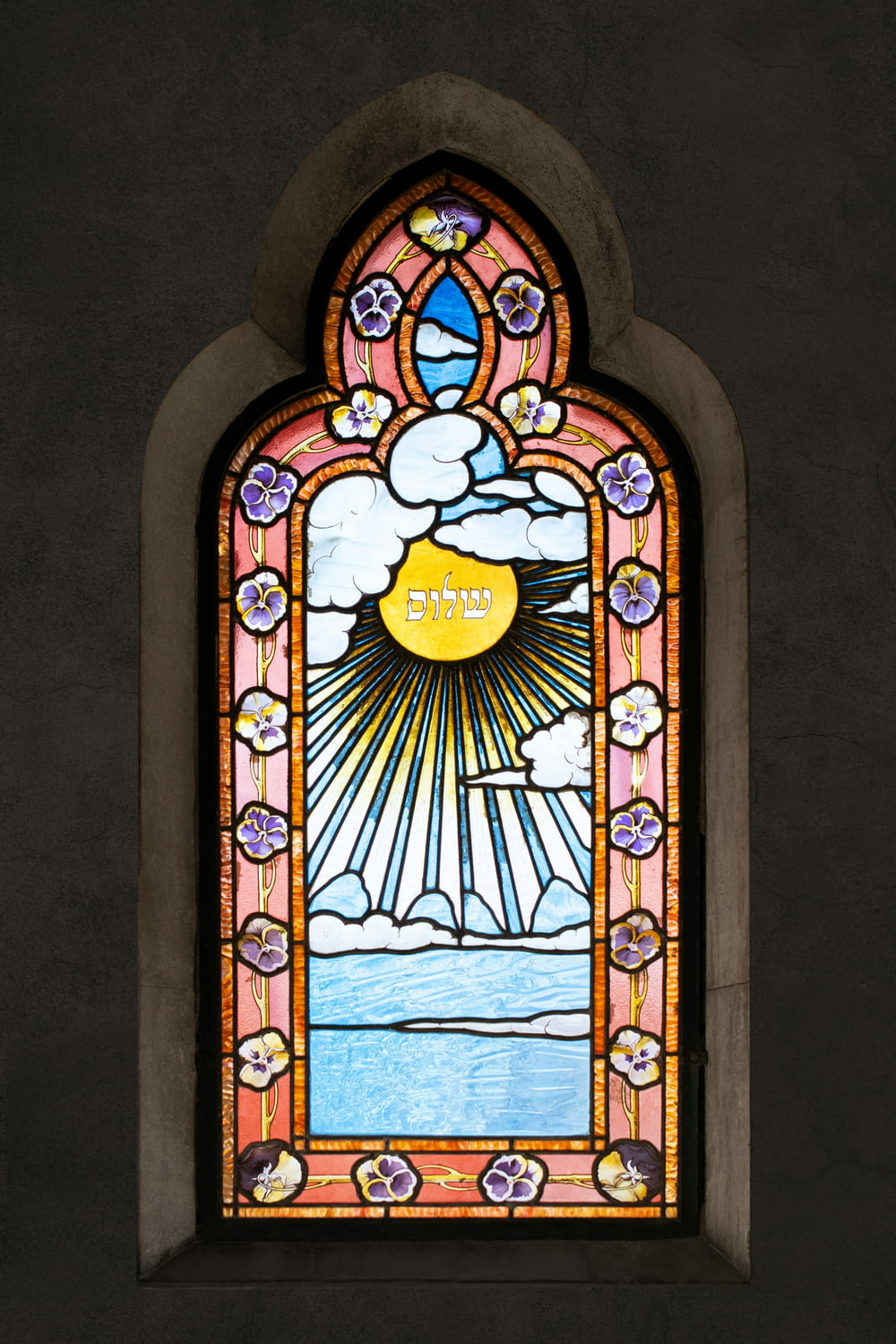 a stained glass window with the sun shining through it