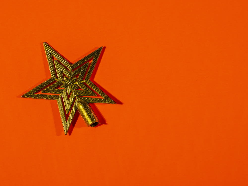 a star shaped brooch sitting on top of an orange surface